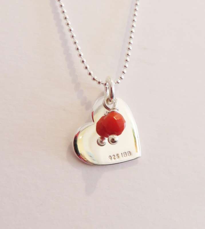 Silver pendant with heart charm and orange stone